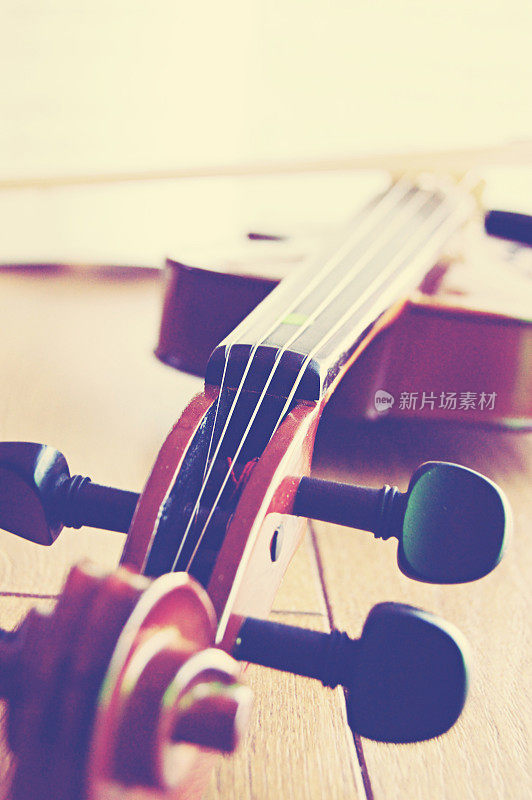 一把小提琴横拍在棕色的木制背景/地板上。垂直拍摄